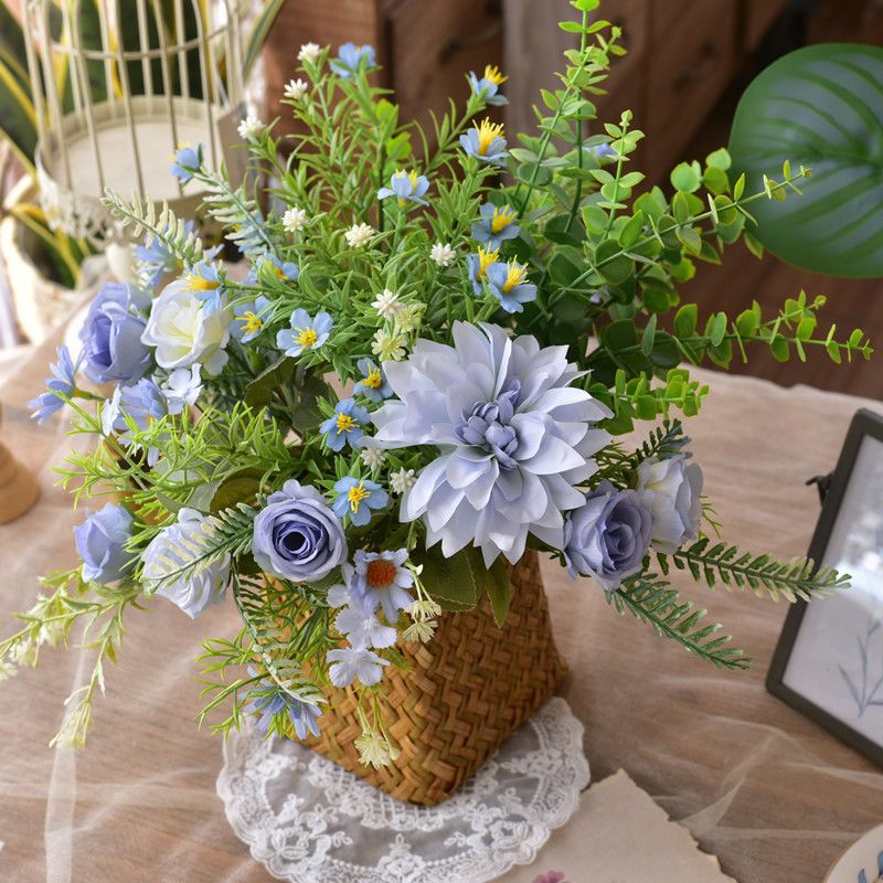 Elegante synthetische Blumenarrangement in geflochtenem Korb