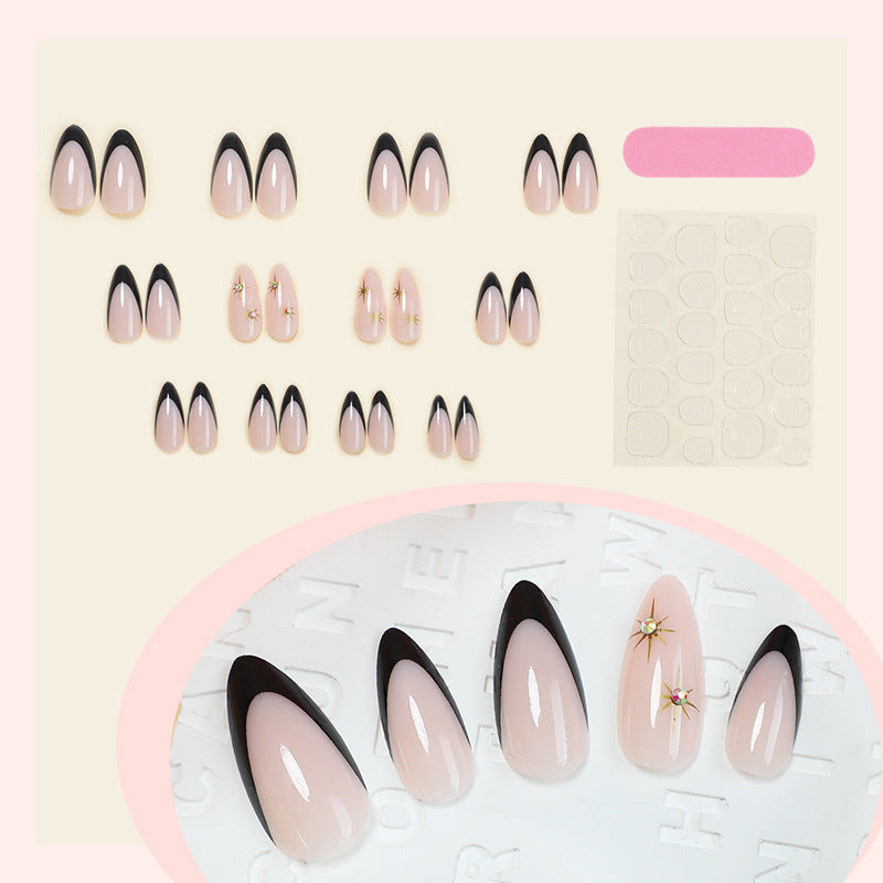 Kunstnagelset mit elegantem Schwarz-Weiß-Design und goldenen Sternenakzenten Brehn