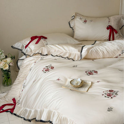 Elegante Satin-Bettgarnitur mit plissiertem Volant, Rosenstickerei und Schleifenapplikation