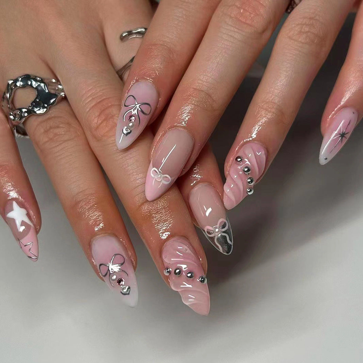 Kunstvolle Nagelkunst mit dekorativen Schleifen und Glitzerakzenten Brehn