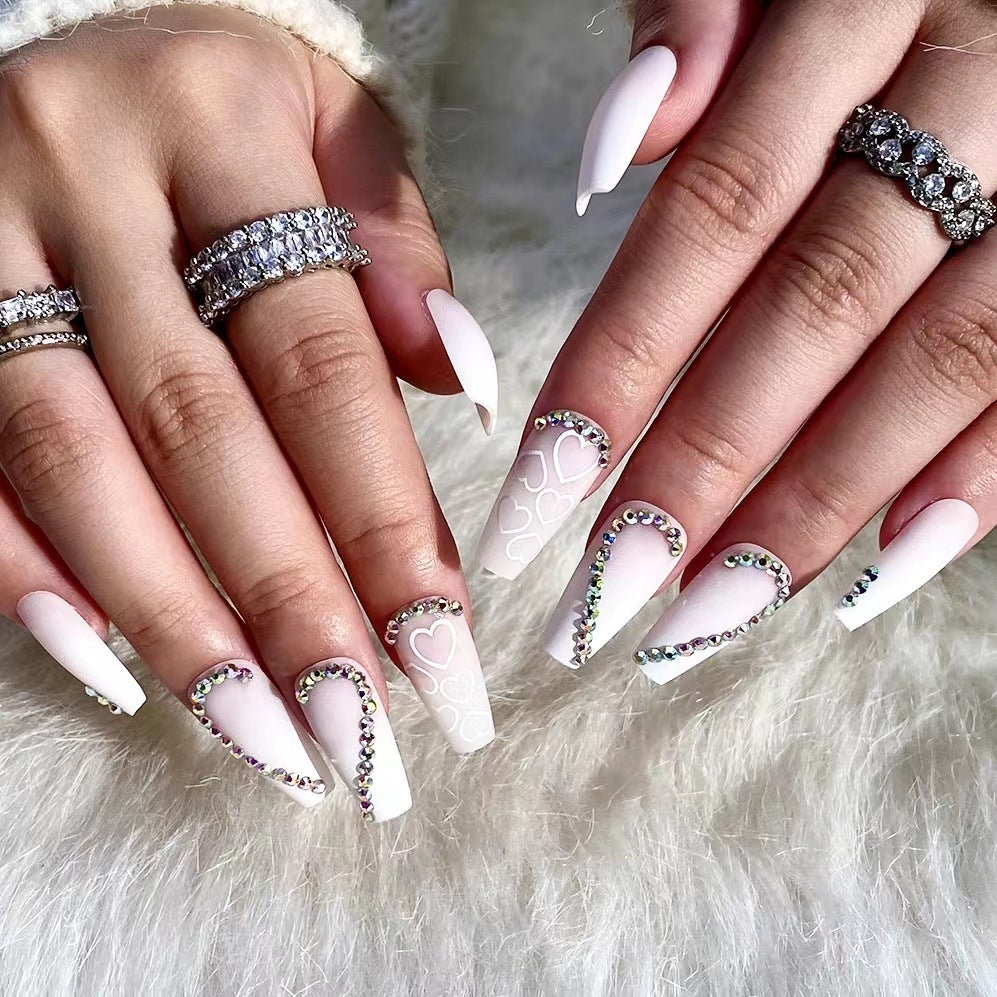Kunstvolle Nagelverlängerungen mit Herzen-Design und Glitzerakzenten Brehn