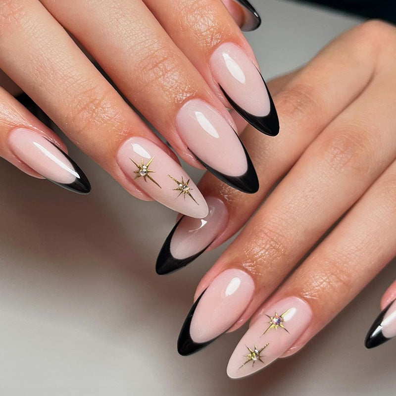 Kunstnagelset mit elegantem Schwarz-Weiß-Design und goldenen Sternenakzenten Brehn