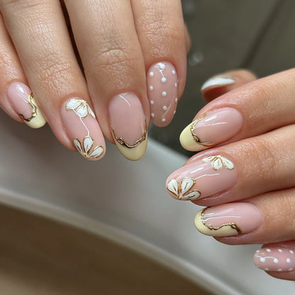 Kunstvolle Nagelverlängerungen mit floralem Design und eleganten Goldakzenten Brehn