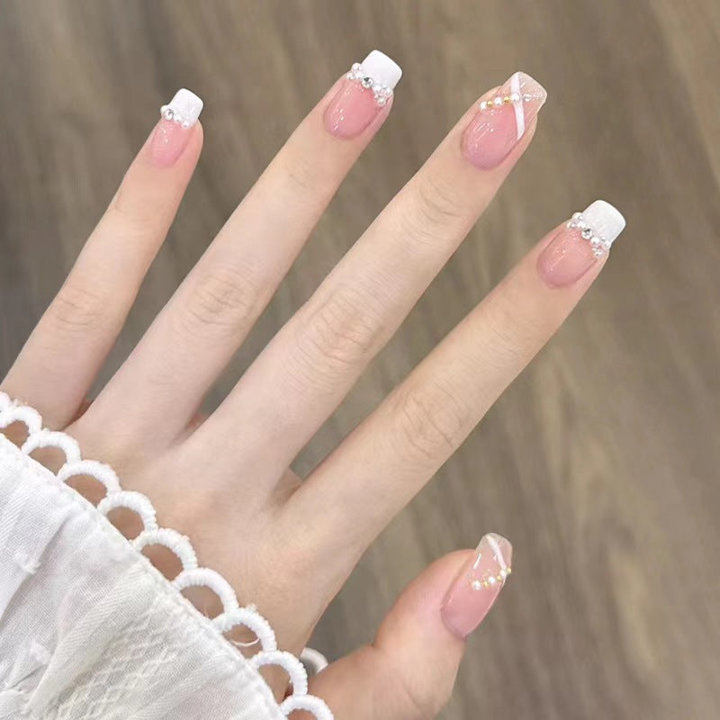 Kunstvolle Nagelkunst mit Schmetterlings- und Perlendetails Brehn