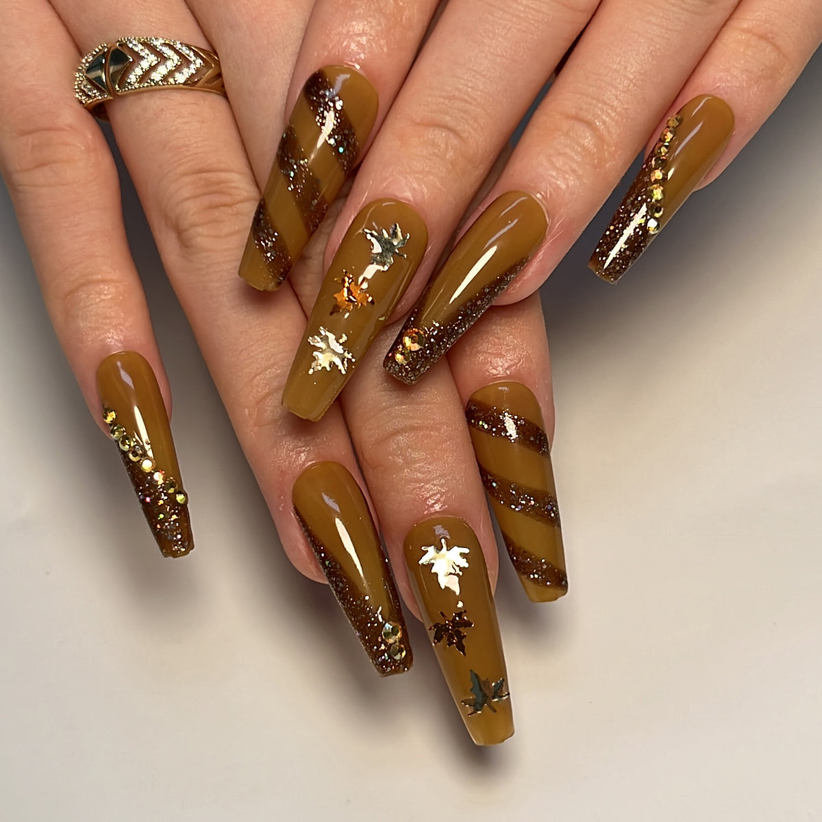 Kunstvolle Nagelkunst mit Glitter- und Blätterdesign Brehn