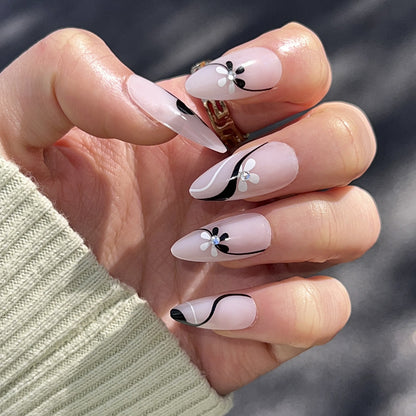 Kunstvolle Nagelverlängerungen mit floralen Akzenten und Glitzerakzenten Brehn