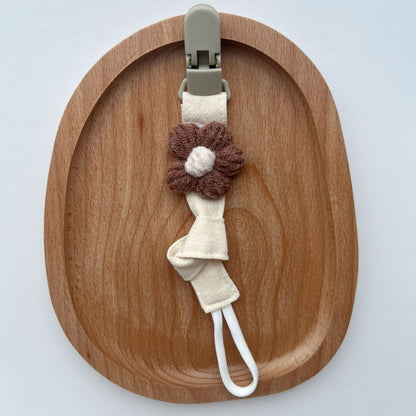 Handgemachter Baumwoll-Schnullerclip mit Gingham-Gurt und gestrickter Blume