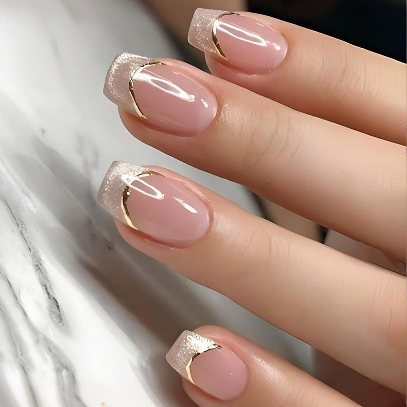 Kunstnagelset mit eleganter Glitzer-French-Spitze und goldenen Verzierungen Brehn