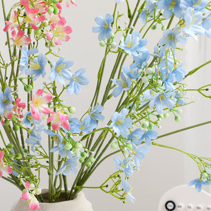 Künstlicher Blütenzweig mit zarten blauen Blumen und grünen Beeren Brehn