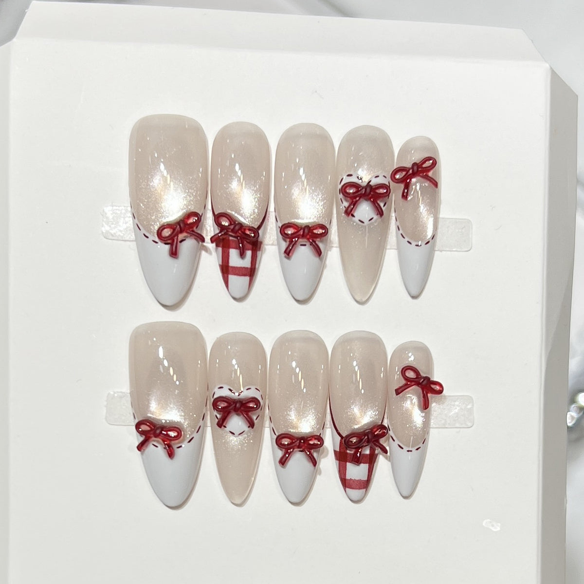 Dekorativer Stiletto Press-On Nagelset mit Schleifenakzenten Brehn
