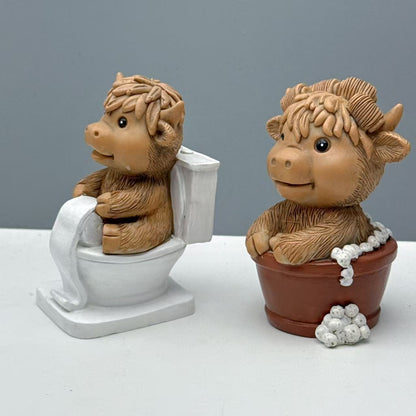 Lustige Dekofigur eines Hochlandrinds auf Toilette Brehn