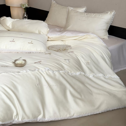 Elegante Bettwäschegarnitur aus seidig-feinem Satin mit bestickten Schleifen und Spitzenbordüre