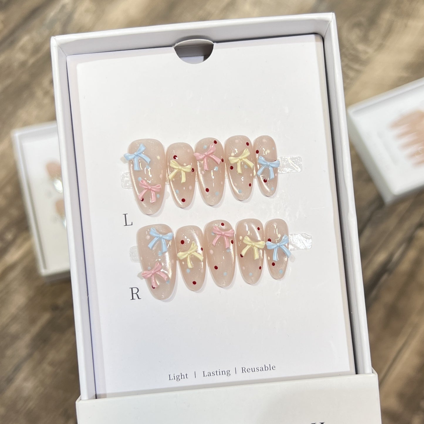 Dekoratives Press-On-Nagelset mit charmantem Bogen und Punkten Brehn
