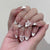 Kunstnagelset mit luxuriösen Verzierungen und funkelnden Details Brehn