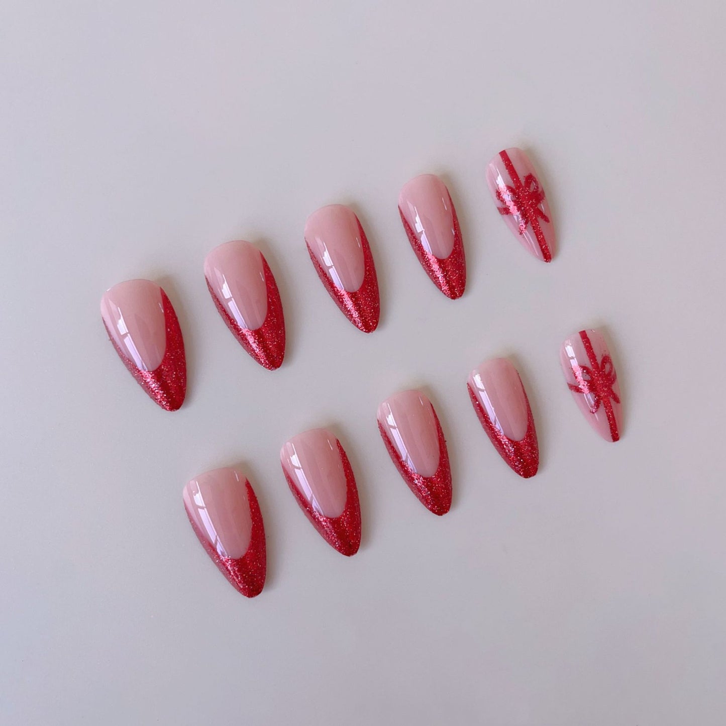 Kunstnagelset mit glamourösen Glitzer-Akzenten und Schleifen-Design Brehn