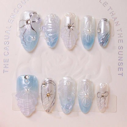 Kunstnagelset mit eleganten Muschel- und Perlenakzenten Brehn