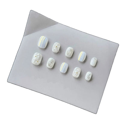 Dekoratives Press-On Nagelset mit elegantem Marmor- und Blumenakzenten