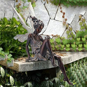 Statue einer sitzenden Fee im Garten