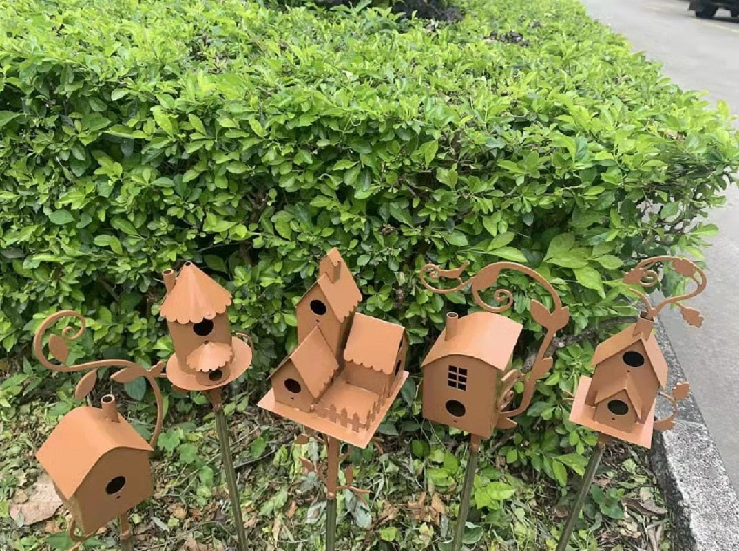 Vogelhaus aus Metall auf Gartenpfahl